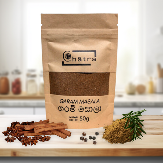 Ceylon Organic House Garam Masala Pack on a kitchen countertop with curry powder, cinnamon, star anise and pepper, the main ingredients of Garam Masala